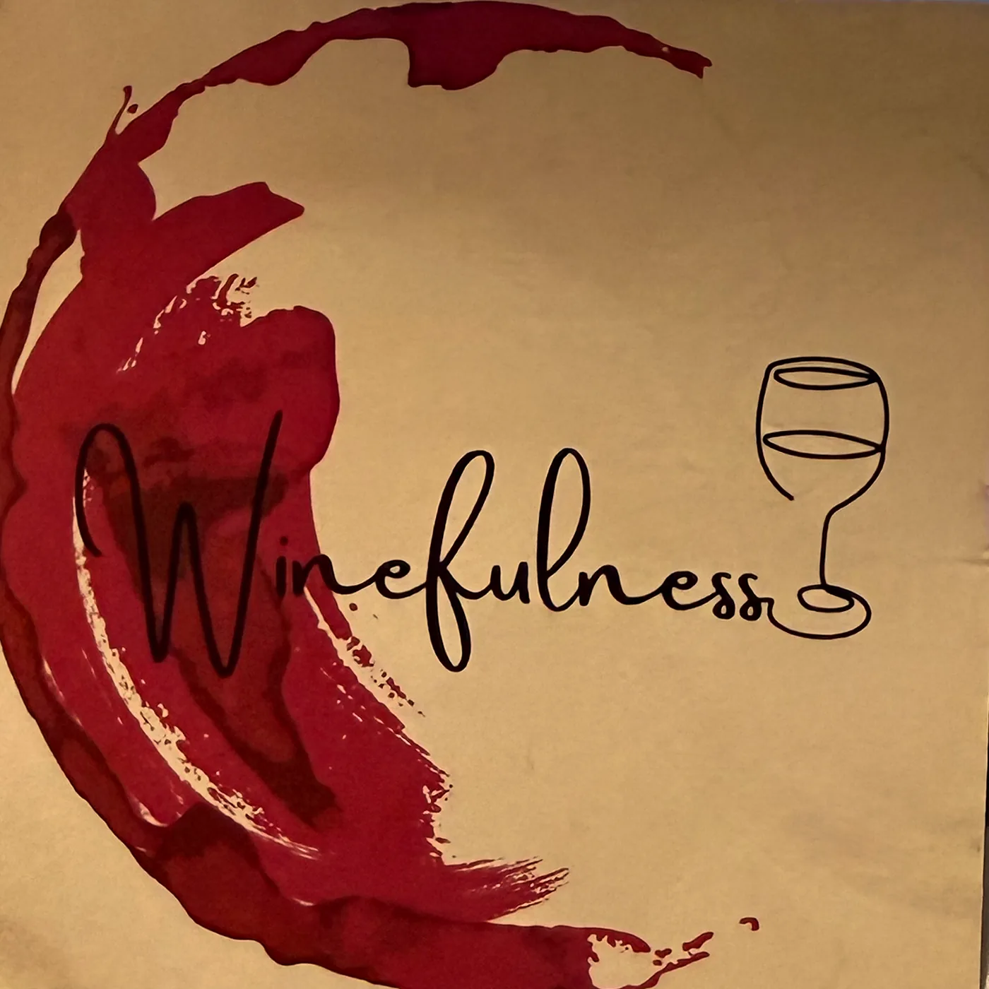 La marca de Winefulness Club impresa sobre papel kraft: una mancha de vino en media luna y el logotipo